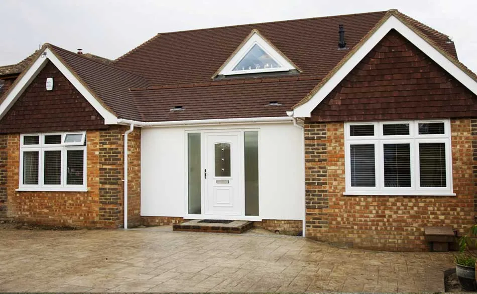 renovated brick house with a white door and windows.
