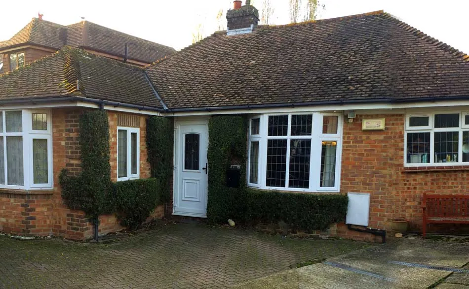A brick house with a white door and windows.